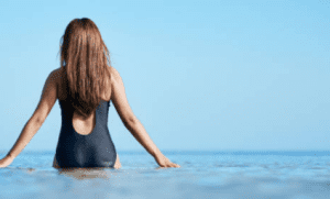 Woman in swimsuit facing the sea
